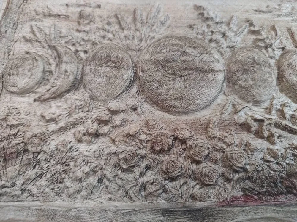 Close up of the burned detail on the carved wooden relief